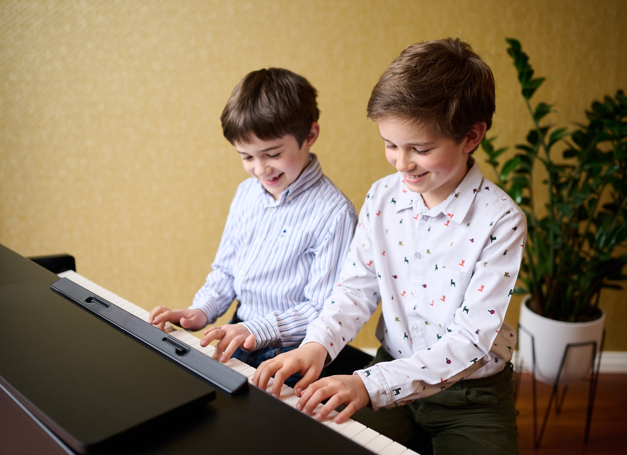 Twee jongens spelen samen digitale piano thuis, tweede sfeerbeeld op de pagina over het huren van een digitale piano bij Piano's Verhulst in Poperinge