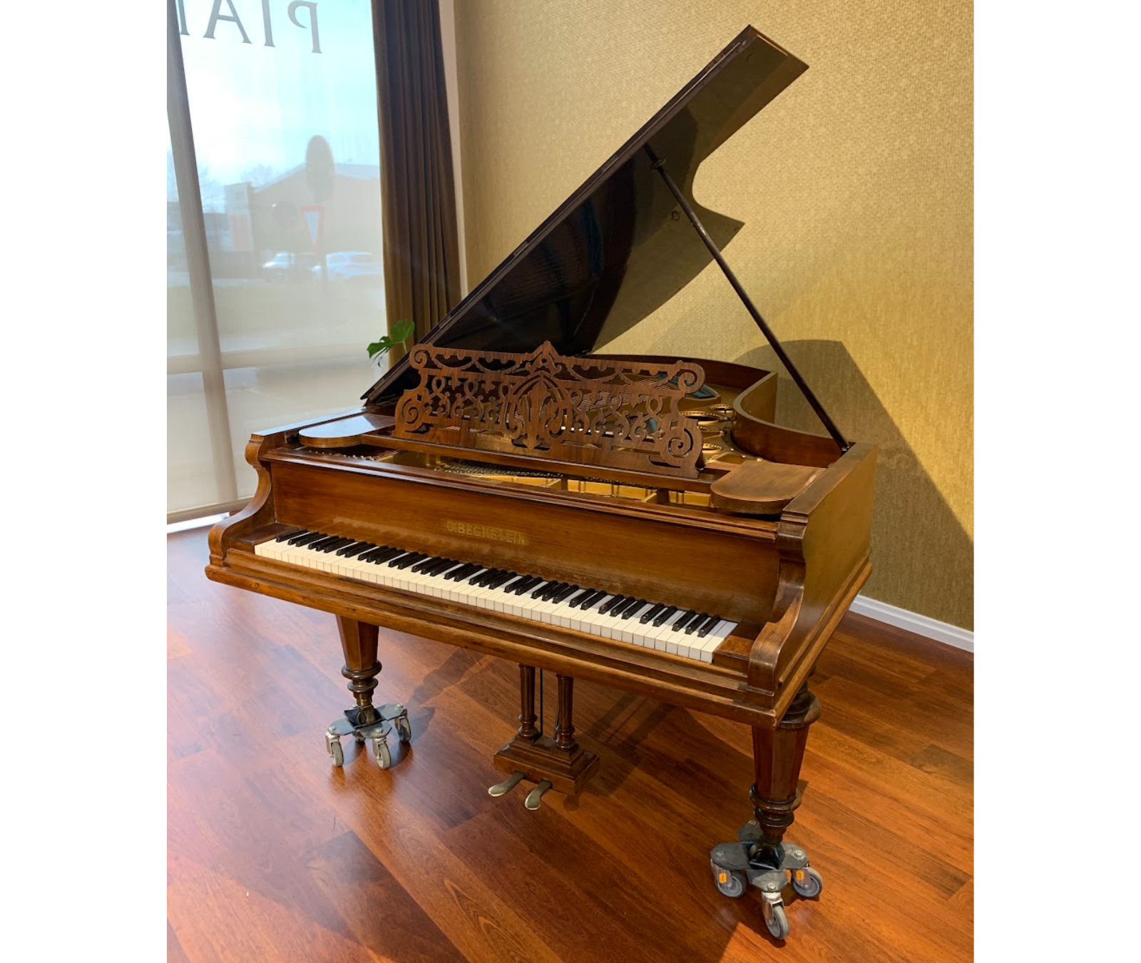 Tweedehands Bechstein vleugel van 2m20, zijaanzicht met zichtbaar "C. Bechstein"-naamplaat boven het klavier, in de toonzaal van Piano's Verhulst